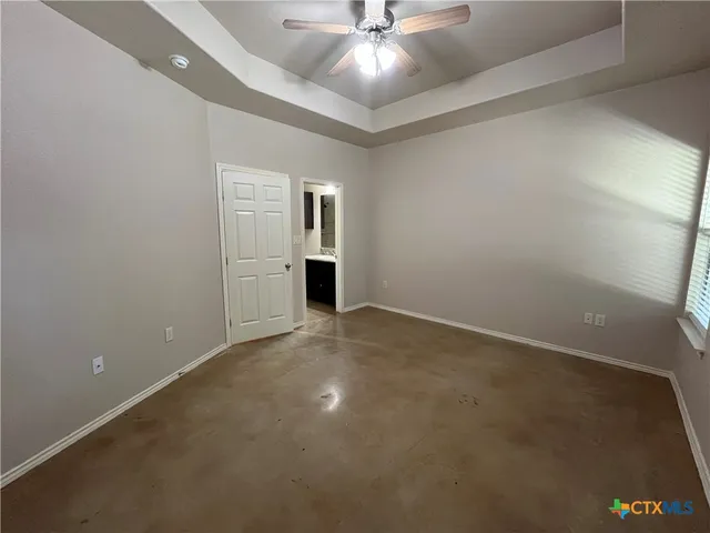 en empty room with windows and fan