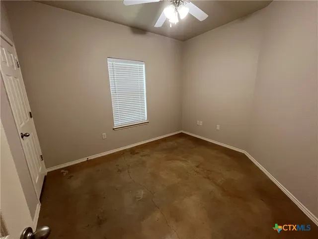 an empty room with a chandelier fan
