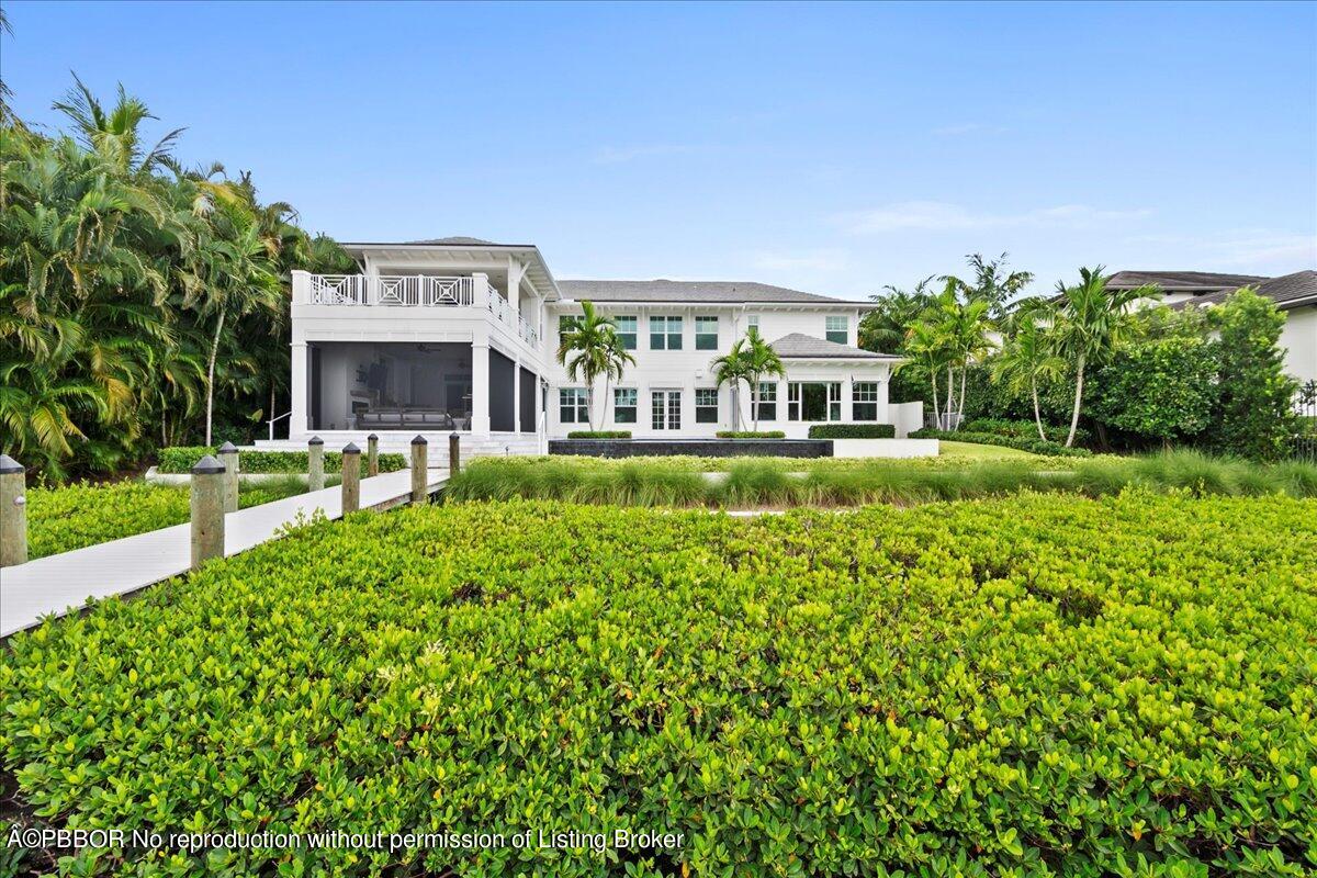 159 Commodore Drive Jupiter, FL 33477 - Photo 14 of 20 a view of a house with a big yard potted plants and large tree