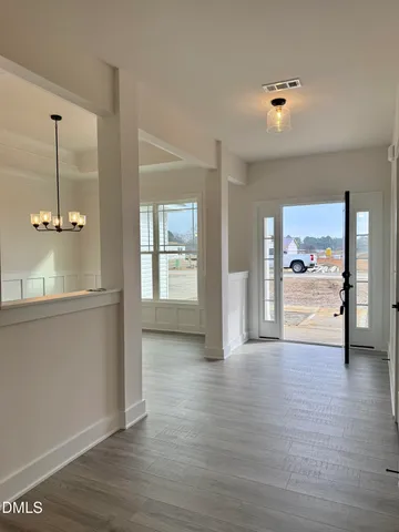 a view of a big room with wooden floor and windows