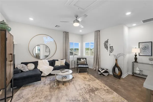 a living room with furniture a clock and a large window