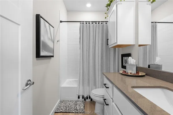 a bathroom with a granite countertop sink toilet and shower