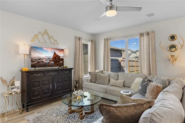 a living room with furniture a rug and a flat screen tv