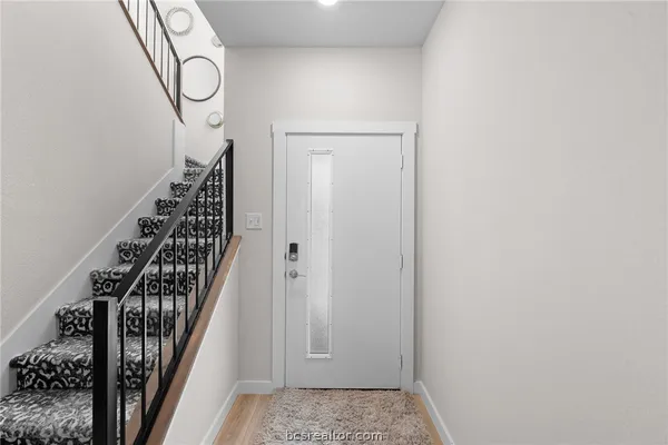 a view of a hallway with wooden floor and entryway