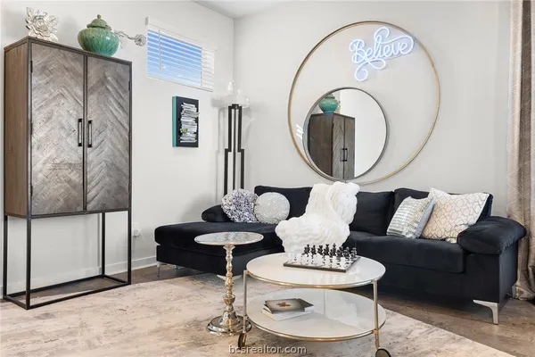 a living room with furniture a mirror and a lamp