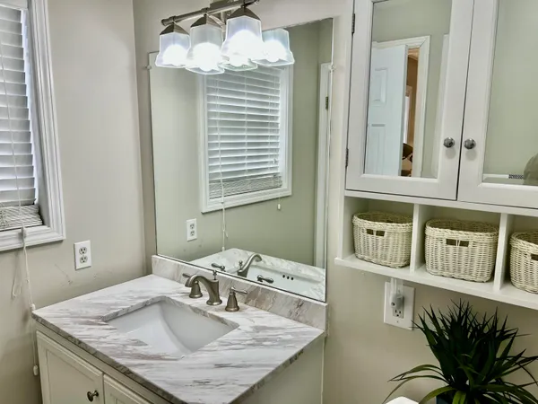 a bathroom with a granite countertop sink a mirror and vanity