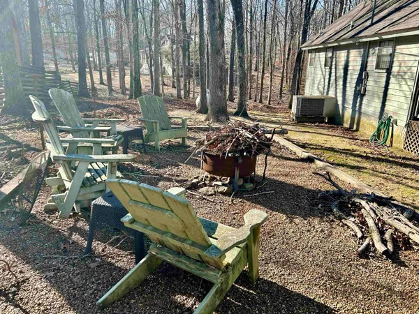 a view of a chairs and fire pit in backyard