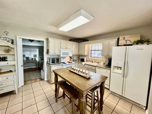 a kitchen with a refrigerator a stove a sink and a dining table