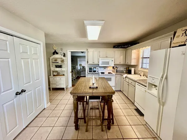 a kitchen with stainless steel appliances a refrigerator a stove a sink dishwasher and a refrigerator with wooden floor