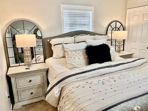 a bedroom with a bed and a mirror on dresser