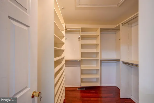 a view of walk in closet with empty racks