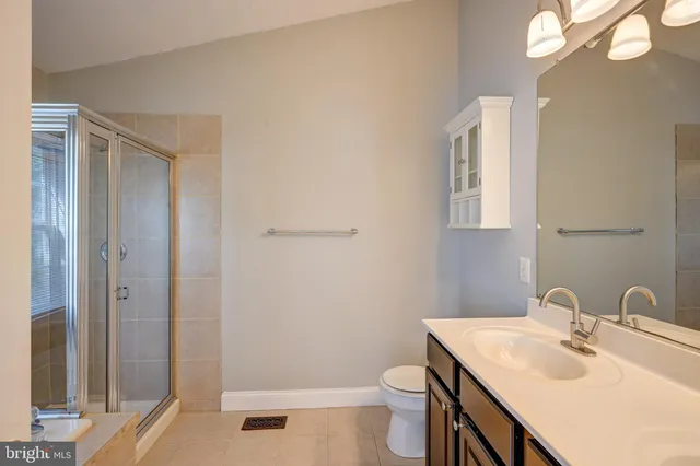 a bathroom with a sink toilet vanity and shower