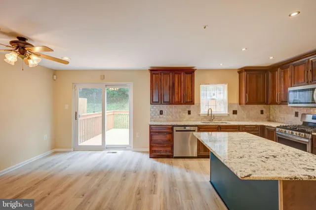 a large kitchen with cabinets wooden floor and stainless steel appliances