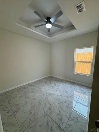 an empty room with windows and ceiling fan