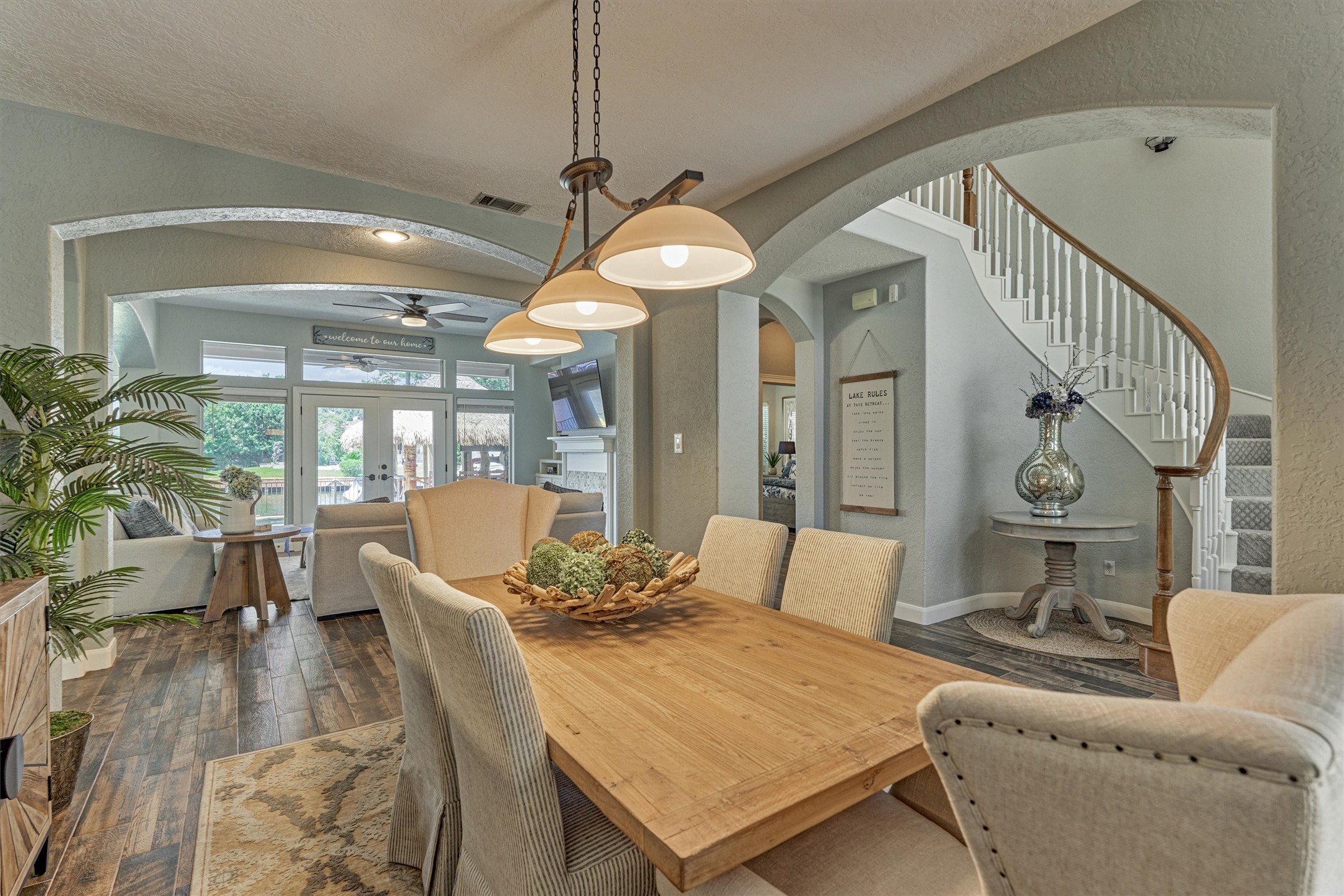 202 Edgemar Road Montgomery, TX 77356 - Photo 11 of 50 Designed for comfort and flow, the custom-lit dining area transitions seamlessly into a welcoming living space. Graceful arches frame the room, while double doors open to the back patio where an automated shade ensures cool comfort even in the heat of Texas summers.