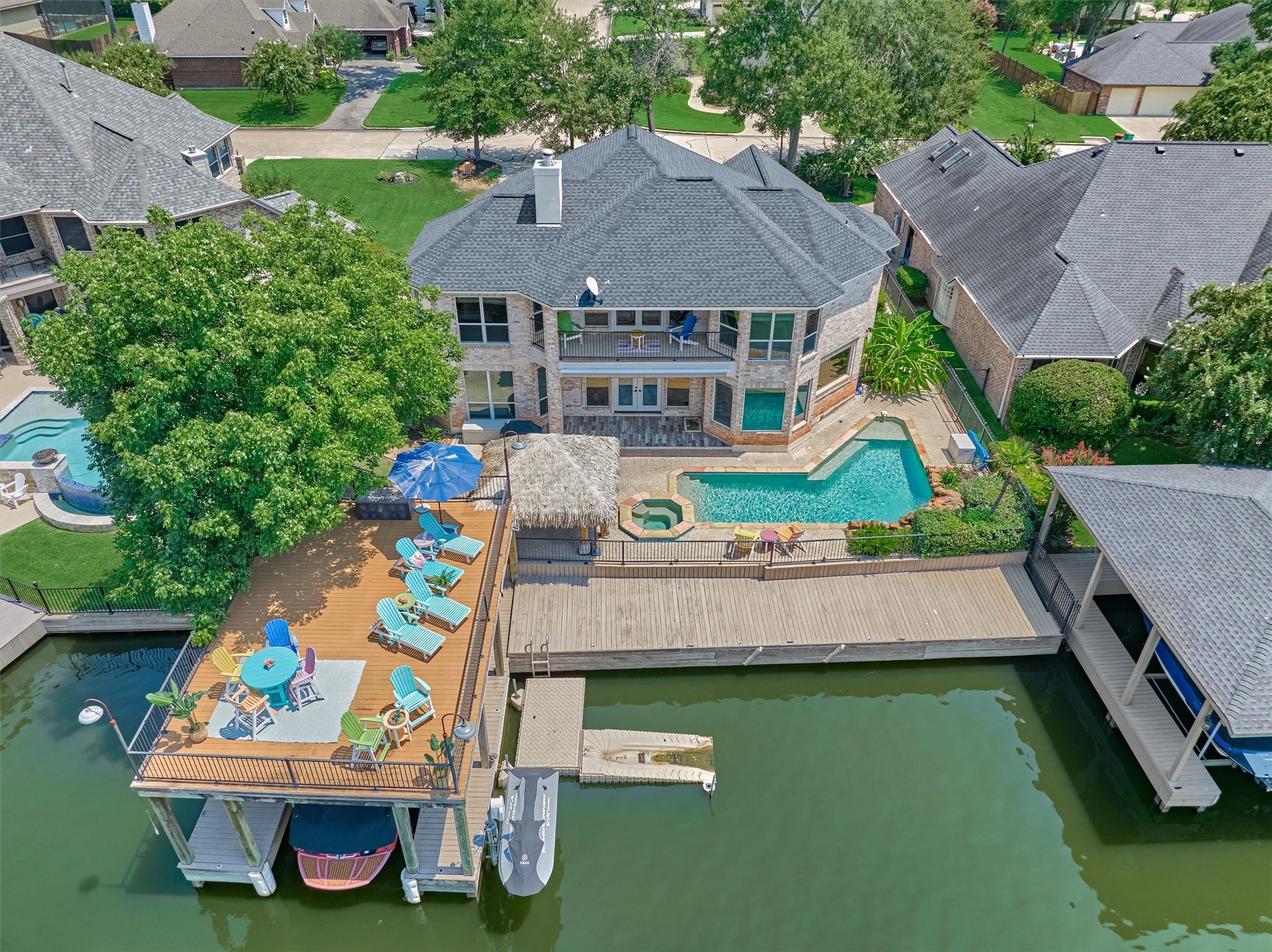 202 Edgemar Road Montgomery, TX 77356 - Photo 5 of 50 The expansive TREX sundeck sets the stage for unforgettable gatherings, while the Margaritaville-inspired Tiki hut bar invites ultimate poolside relaxation. A private dock with boat lift and slip provides seamless access to the lake, making this home a true paradise for boating enthusiasts.
