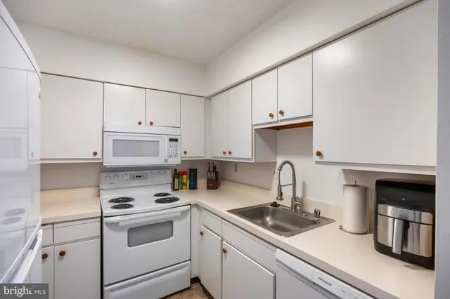 a kitchen with appliances a sink and cabinets