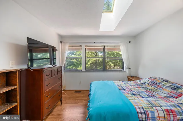a bedroom with a bed and a flat tv screen on dresser
