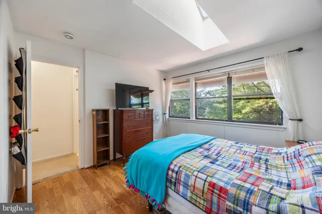 a bedroom with a bed and a flat tv screen on dresser