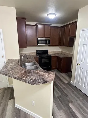 a kitchen with stainless steel appliances granite countertop a sink stove microwave and refrigerator