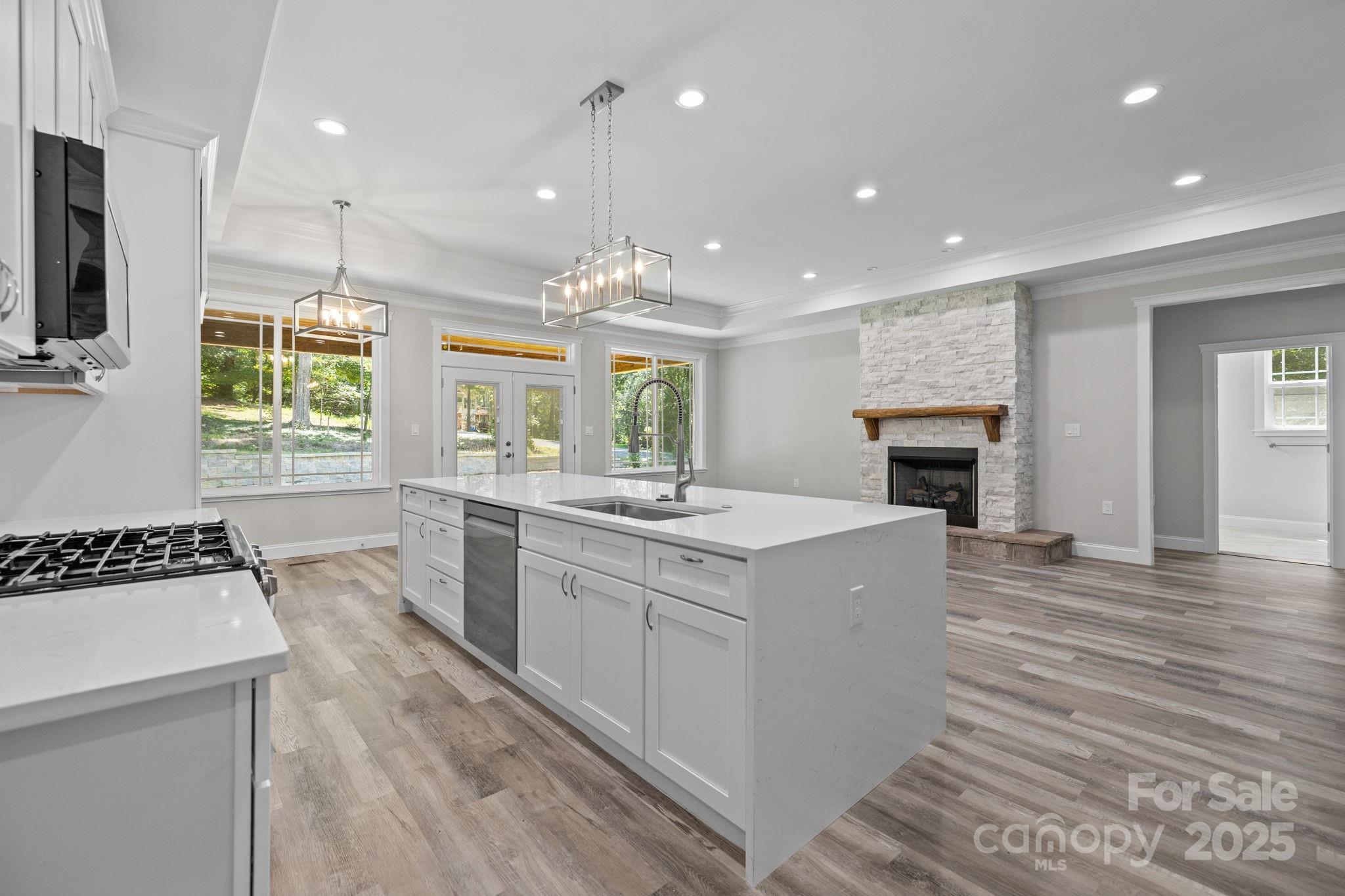 4531 Deer Run Rock Hill, SC 29732 - Photo 11 of 32 a kitchen with kitchen island granite countertop a stove top oven a sink dishwasher and a fireplace with wooden floor