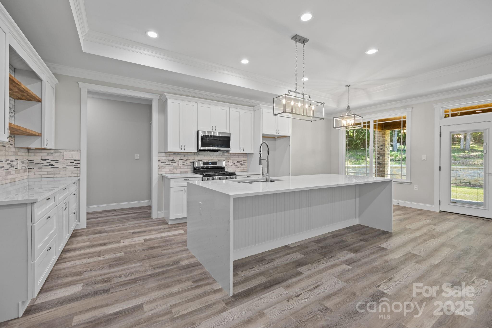 4531 Deer Run Rock Hill, SC 29732 - Photo 4 of 32 a large white kitchen with granite countertop a stove top oven a sink dishwasher and a fireplace with wooden floor