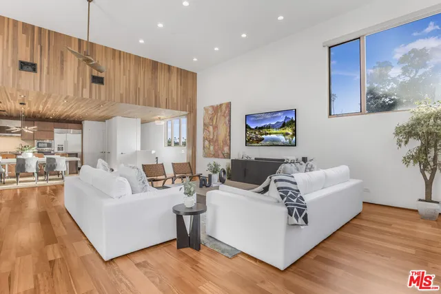 a living room with furniture wooden floor and a large window