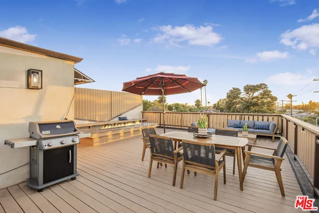 a view of a roof deck with table and chairs