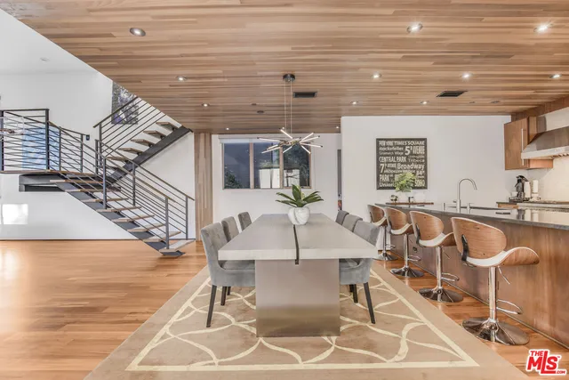 a view of a dining room with furniture a rug and wooden floor