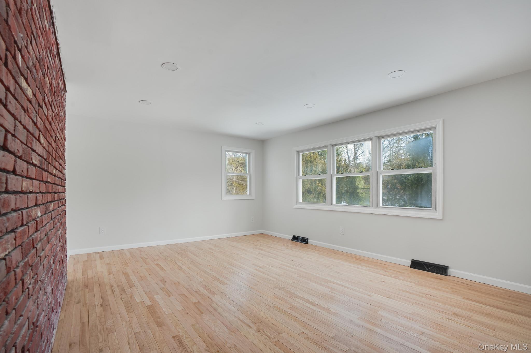 629 Twin Arch Road Rock Tavern, NY 12575 - Photo 2 of 24 an empty room with wooden floor and windows