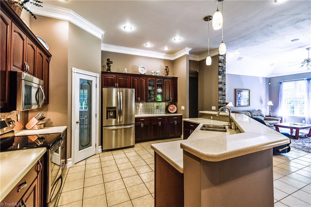 1295 East Westmoreland Road King, NC 27021 - Photo 8 of 17 Super sized Kitchen with abundant counter space and ample bar seating adjacent to Keeping Room with floor to ceiling stone fireplace