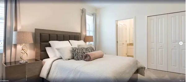 a large bed sitting in a bedroom next to a window
