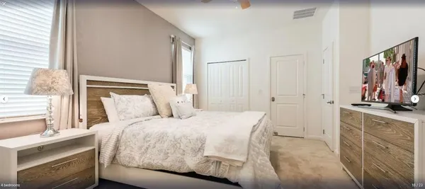 a bedroom with a bed and a flat screen tv