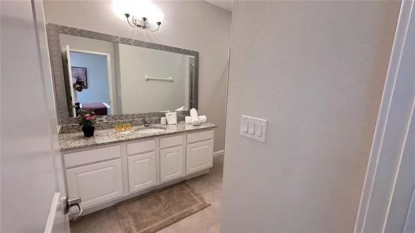 a bathroom with a granite countertop sink and a mirror