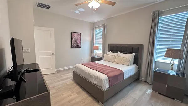 a spacious bedroom with a bed and a chandelier