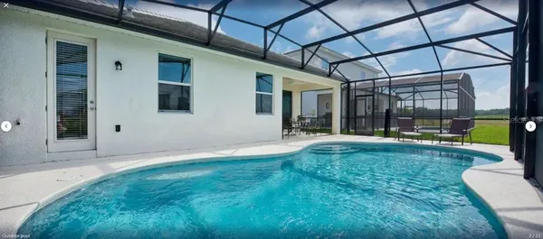 a swimming pool with yard in front of it