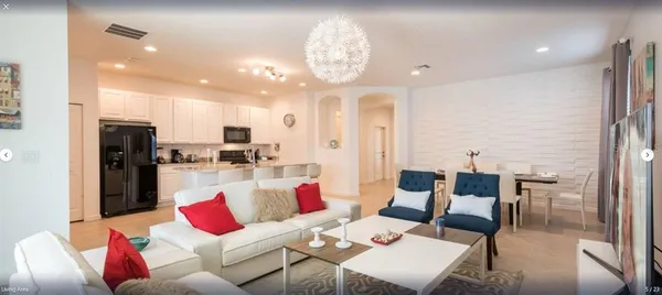 a living room with furniture and kitchen view