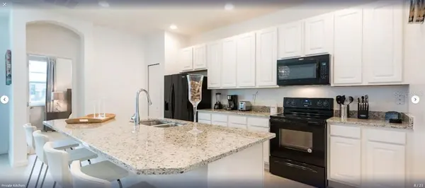 a kitchen with stainless steel appliances granite countertop a stove top oven a sink a refrigerator and white cabinets