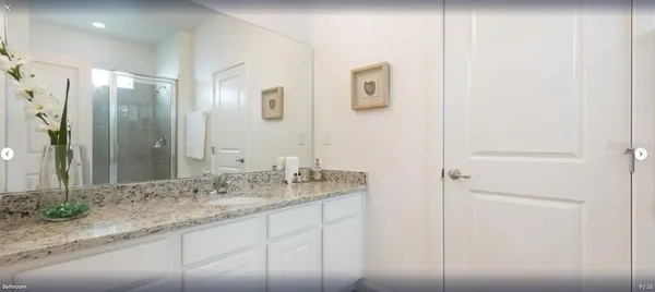 a bathroom with a granite countertop sink and a mirror