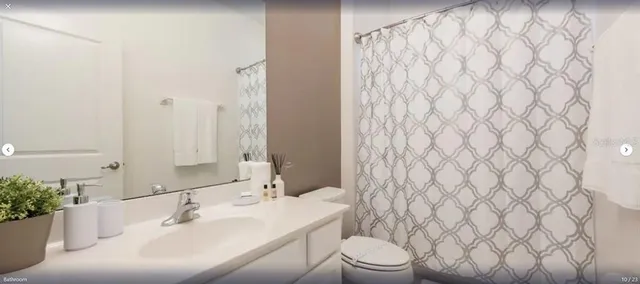 a bathroom with a sink a toilet and shower curtain