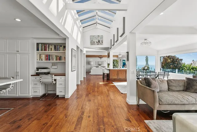 a kitchen with stainless steel appliances kitchen island granite countertop a refrigerator a stove a sink dishwasher and a dining table with wooden floor