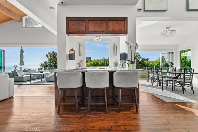 a kitchen with stainless steel appliances granite countertop a stove oven and a dining table with wooden floor