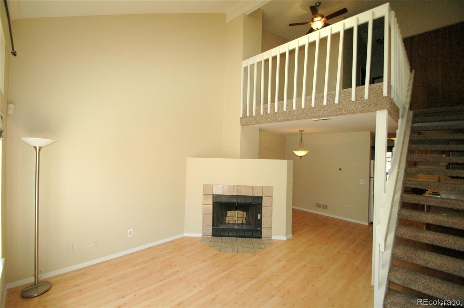 165 South Sable Boulevard, Unit R23 Aurora, CO 80012 - Photo 2 of 11 a view of a livingroom with wooden floor and a fireplace