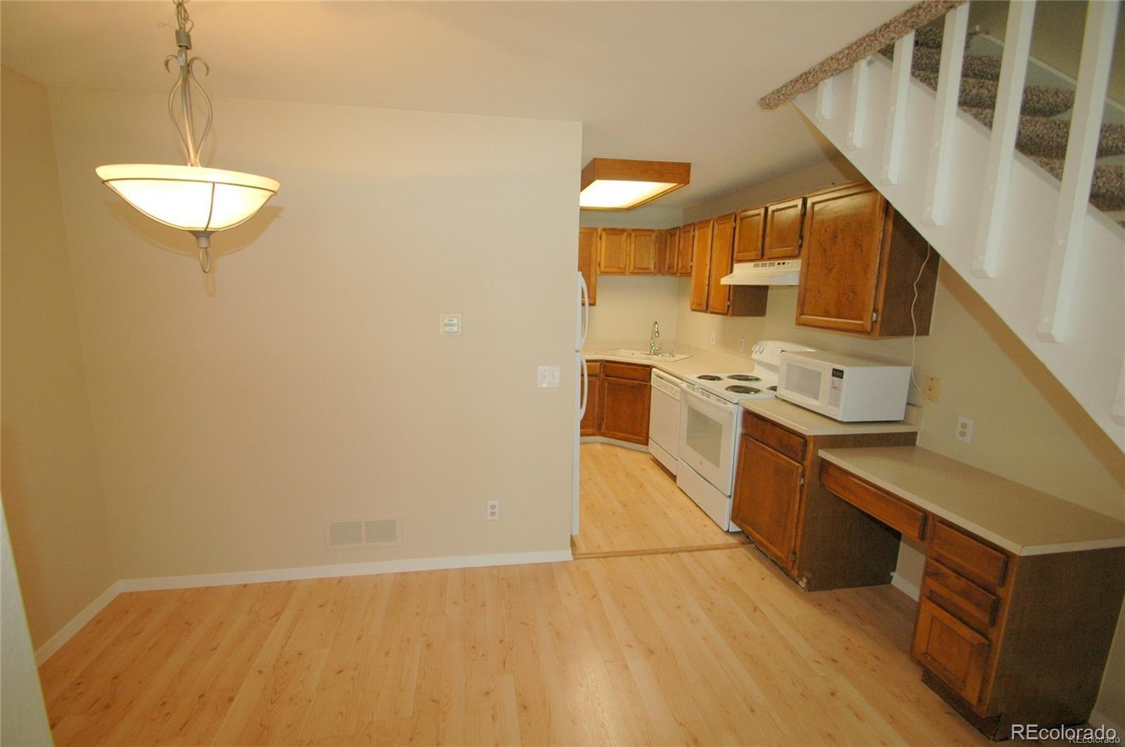 165 South Sable Boulevard, Unit R23 Aurora, CO 80012 - Photo 5 of 11 a kitchen with stainless steel appliances a stove and a refrigerator