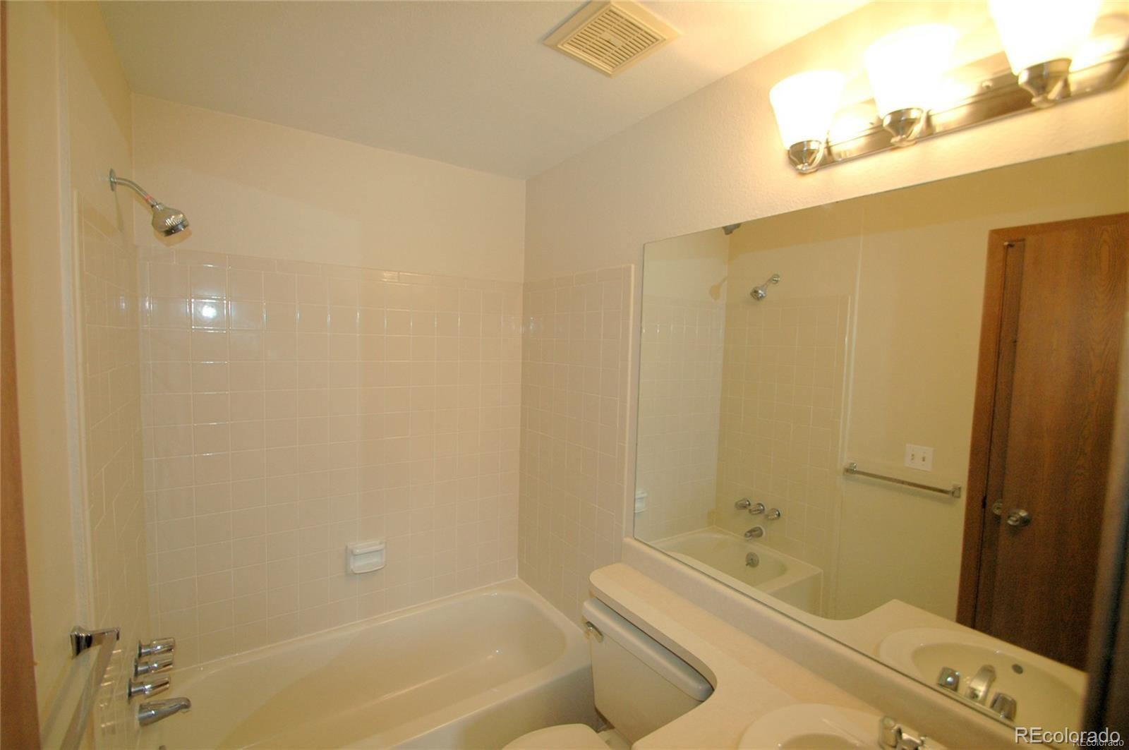 165 South Sable Boulevard, Unit R23 Aurora, CO 80012 - Photo 6 of 11 a bathroom with a tub a sink and a shower