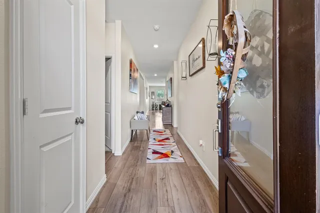 a view of a hallway with wooden floor and stairs