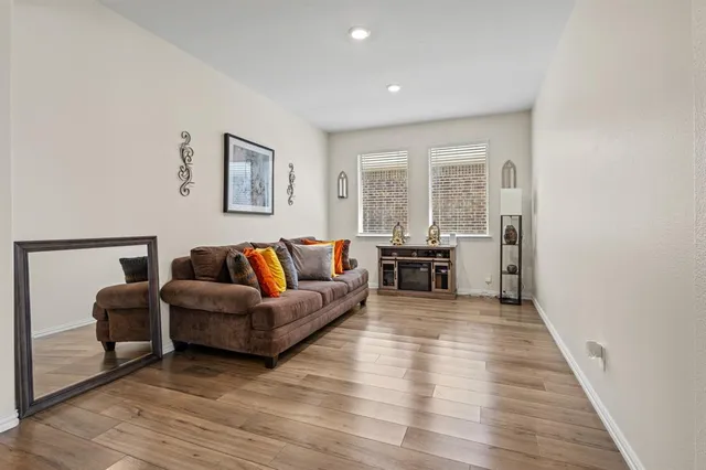 a living room with furniture and a wooden floor