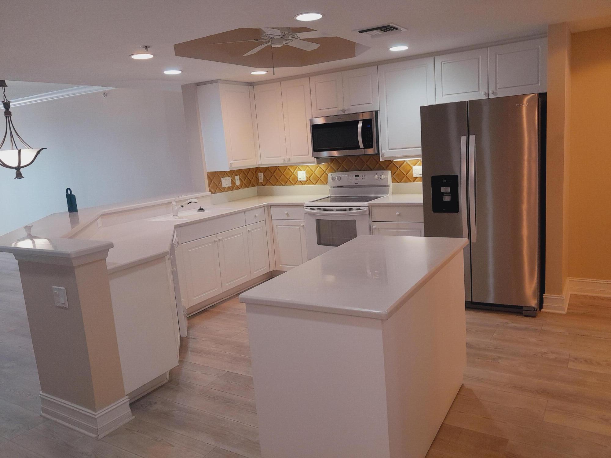 480 Sail Lane, Unit 302 Merritt Island, FL 32953 - Photo 5 of 21 a kitchen that has a sink cabinets and refrigerator