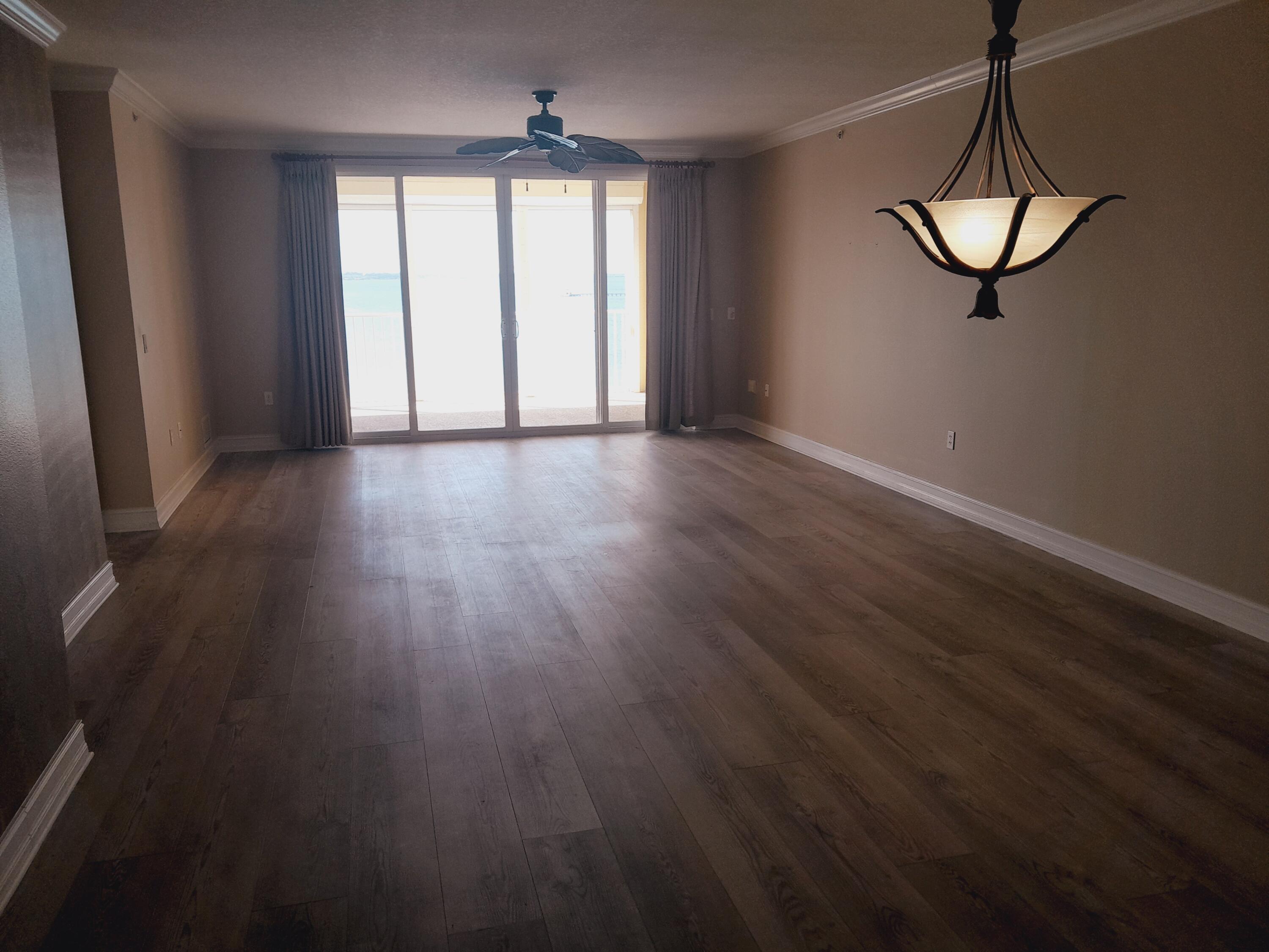 480 Sail Lane, Unit 302 Merritt Island, FL 32953 - Photo 7 of 21 a view of a room with wooden floor and fan