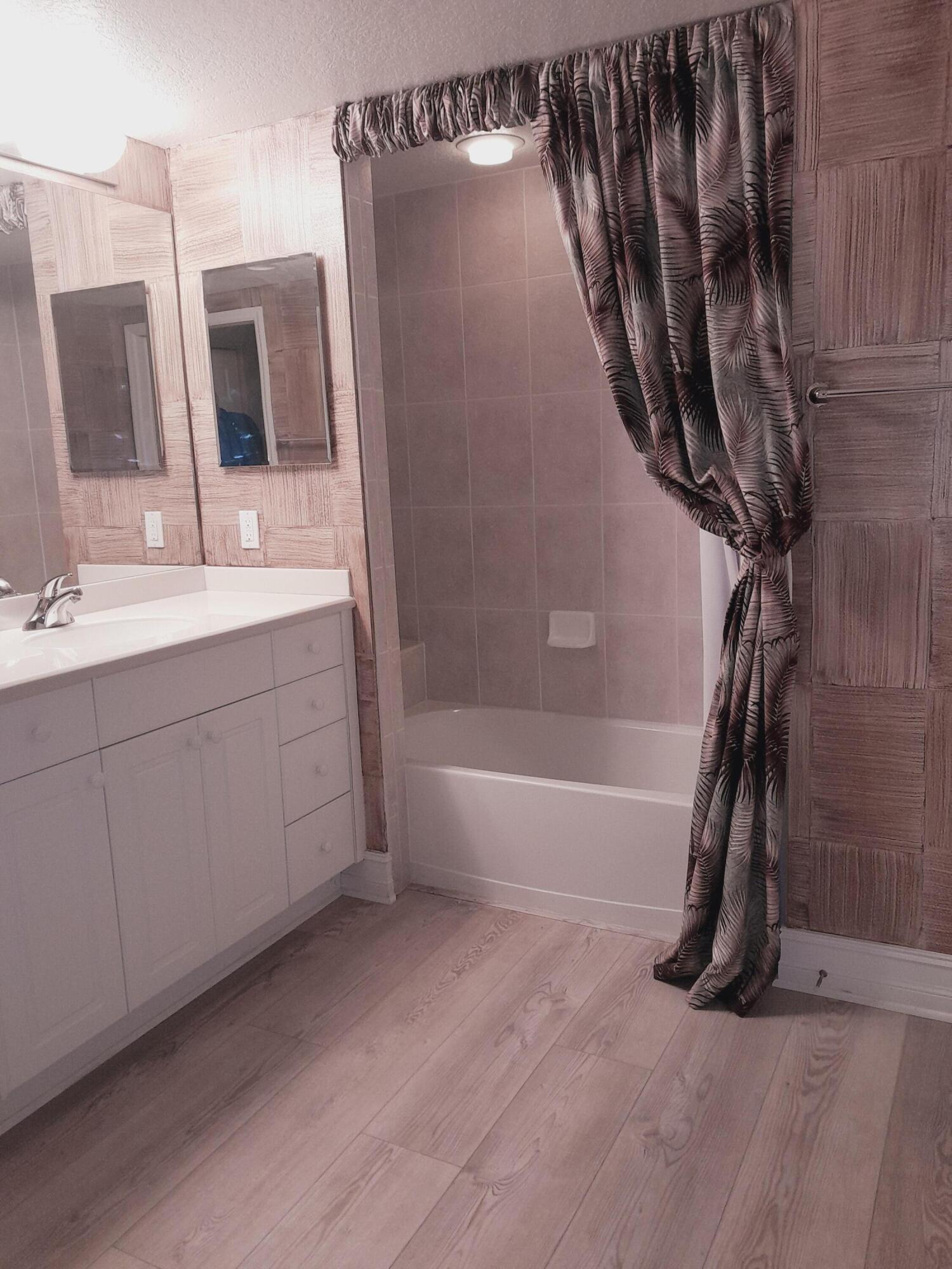 480 Sail Lane, Unit 302 Merritt Island, FL 32953 - Photo 9 of 21 a bathroom with a double vanity sink a mirror and a bathtub